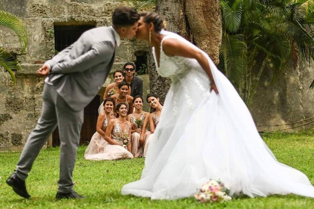 Beso de los novios con las damas de honor al fondo