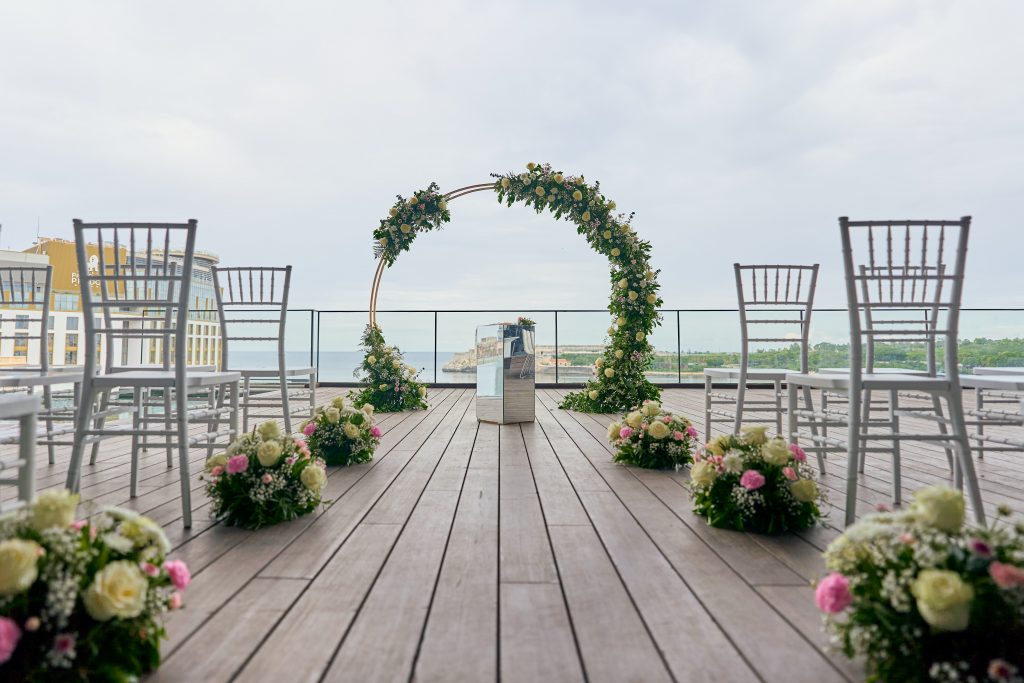 Pasillo de madera con flores hacia el arco de la ceremonia
